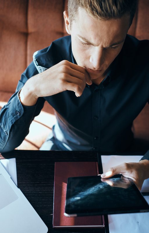 Savvy executive engrossed in digital insights on his sleek tablet.
