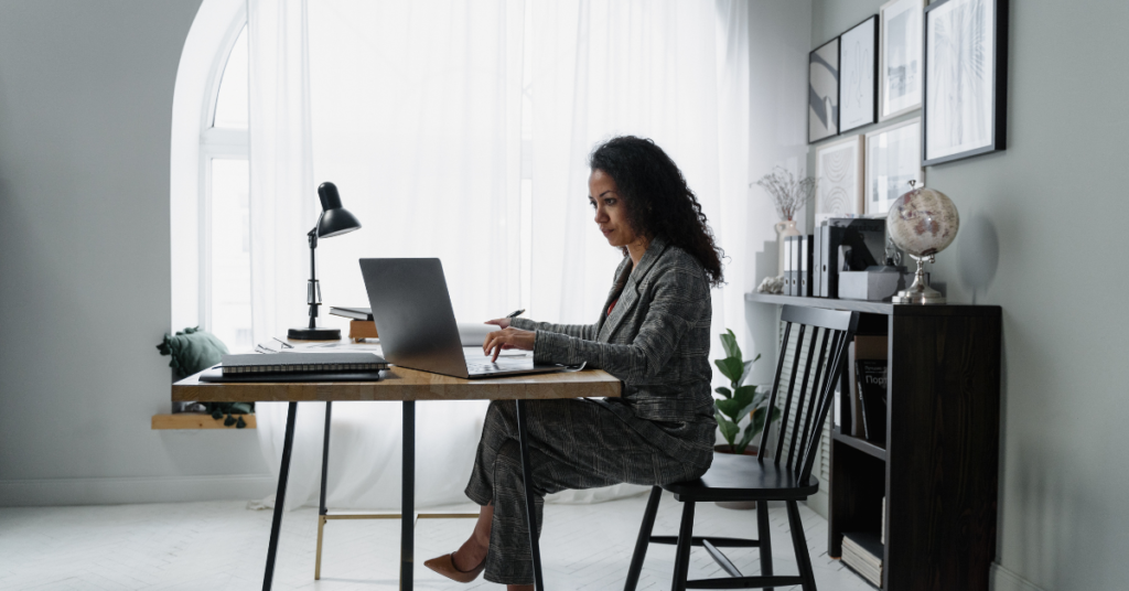Entrepreneur focused on her laptop in a stylish, well-decorated home office.