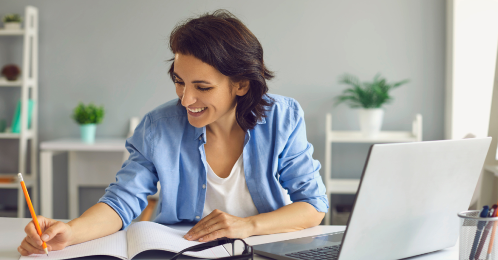 Energetic woman focusing on making money online through studying in a cozy office setup.