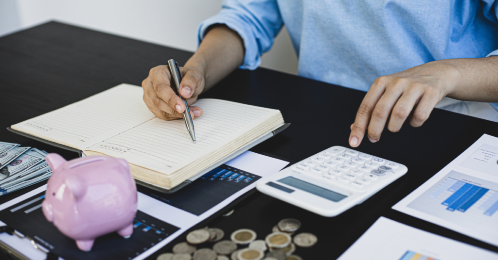 Person budgeting with a calculator and notebook.